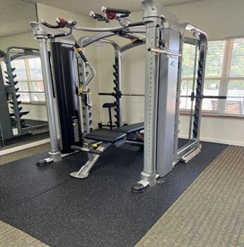 A gym with a black and silver weight machine.